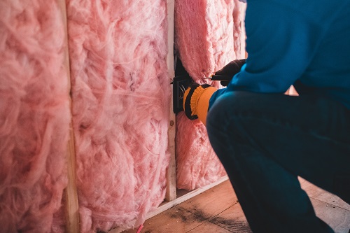 A heat pump requires good insulation: pink insulation being installed.