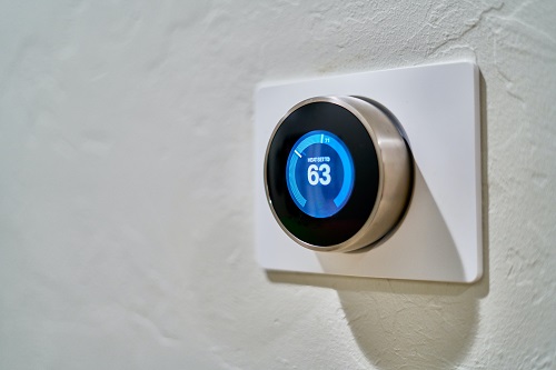 A thermostat set to 63 degrees F